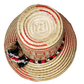 "Handmade colorful Wayuu hat from Colombia and Venezuela, crafted from Iraca palm fibers, decorated with symbolic pompoms."