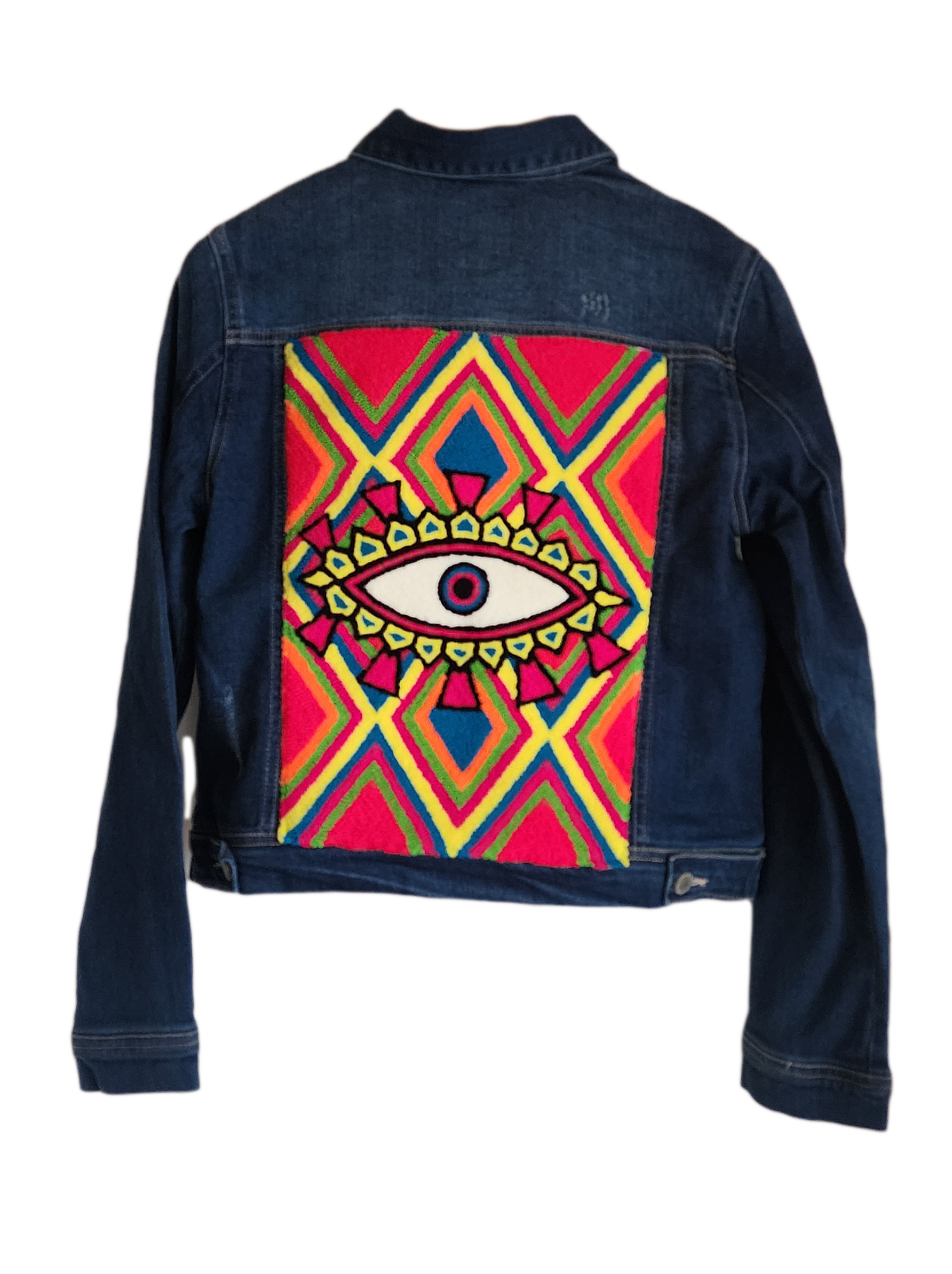 "Handmade denim jacket with colorful Wayuu-inspired punch needle embroidery on the back, showcasing unique bohemian style."