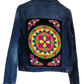 "Handmade denim jacket with colorful Wayuu-inspired punch needle embroidery on the back, showcasing unique artisan craftsmans