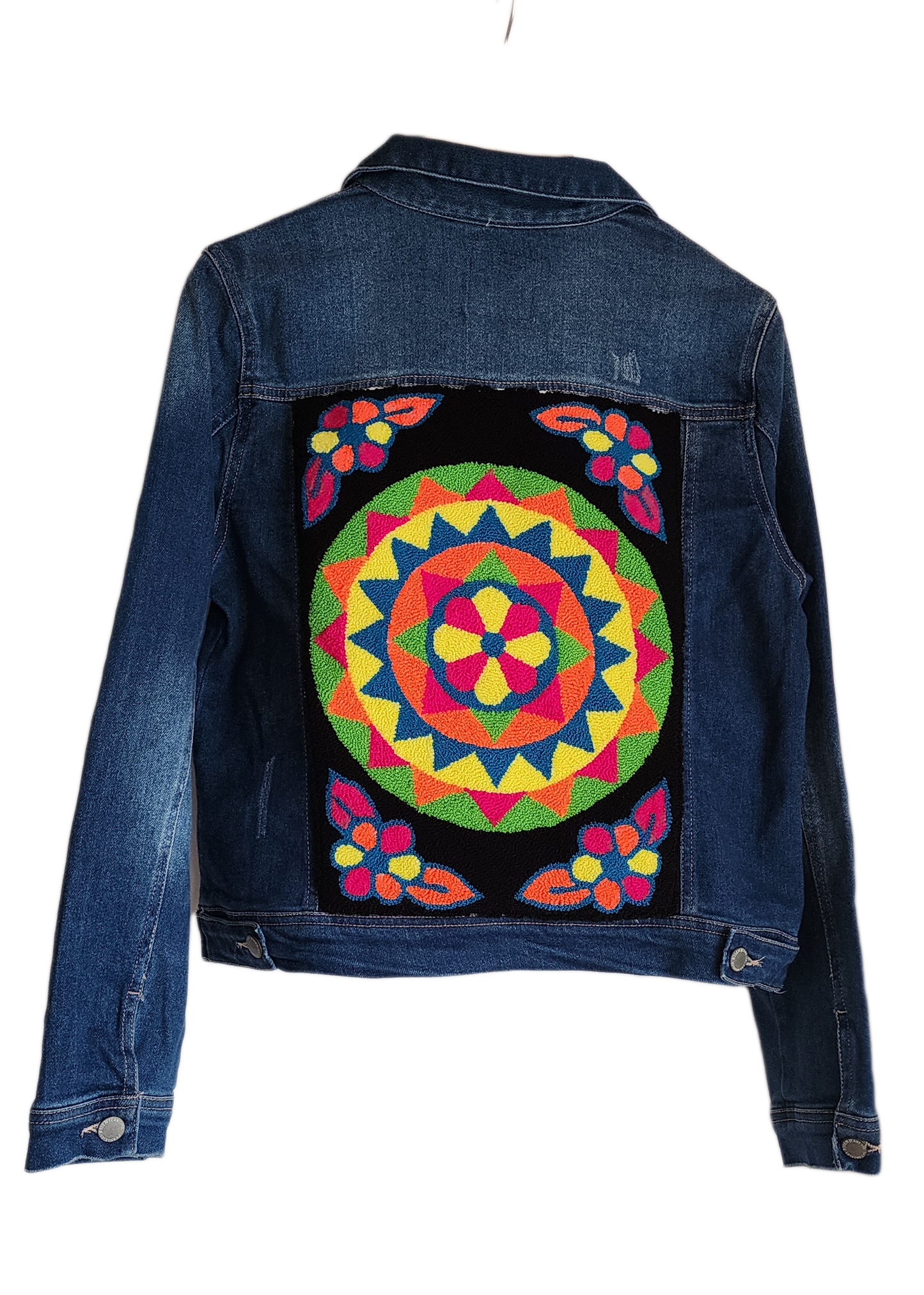 "Handmade denim jacket with colorful Wayuu-inspired punch needle embroidery on the back, showcasing unique artisan craftsmans