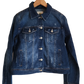 "Handmade denim jacket with colorful Wayuu-inspired punch needle embroidery on the back, showcasing unique bohemian style."
