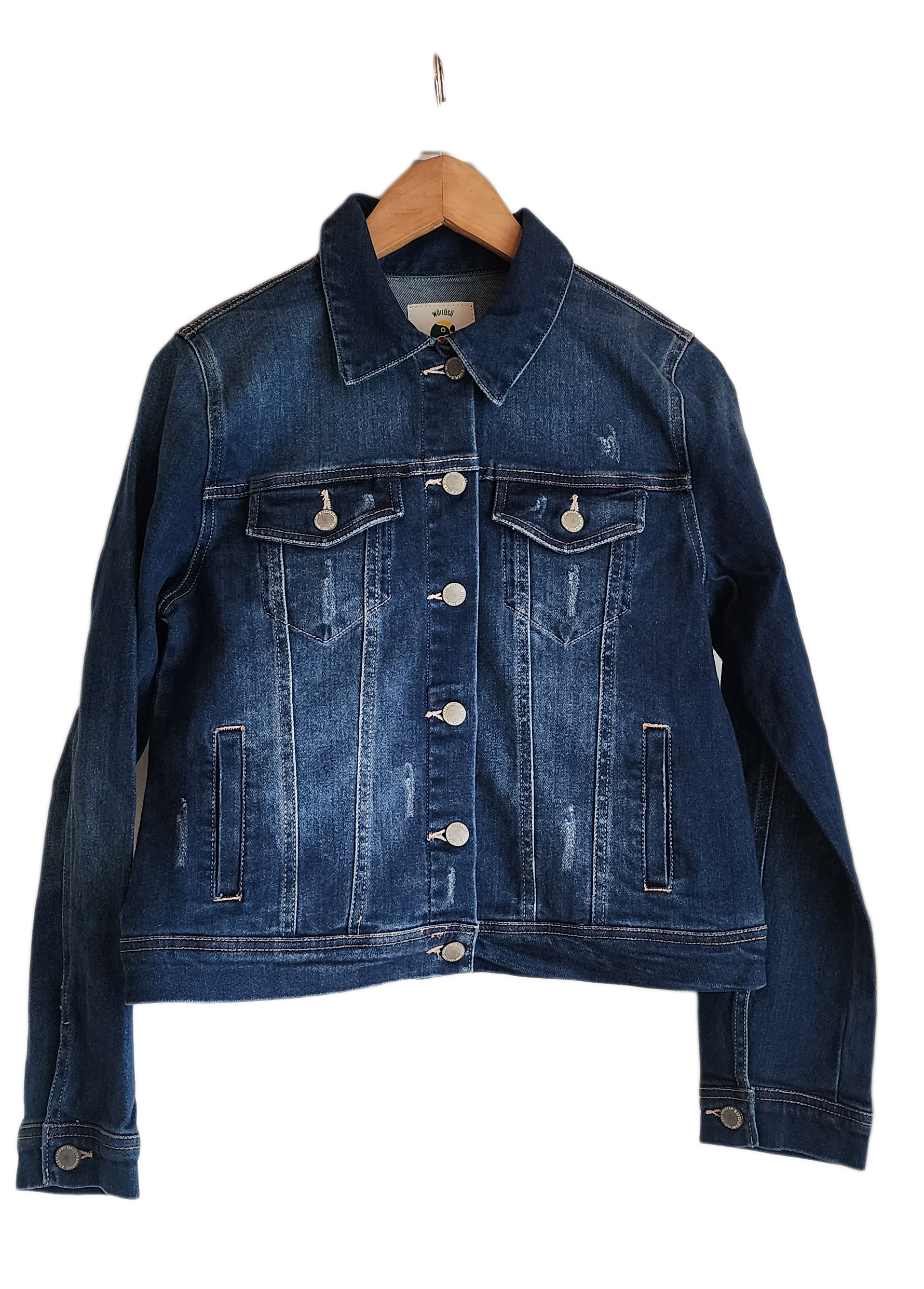 "Handmade denim jacket with colorful Wayuu-inspired punch needle embroidery on the back, showcasing unique bohemian style."