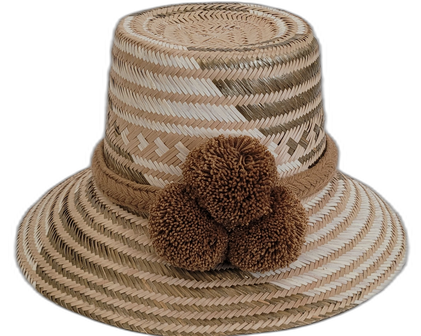 Handmade Wayuu straw hat in earthy beige tones with brown pompoms.

