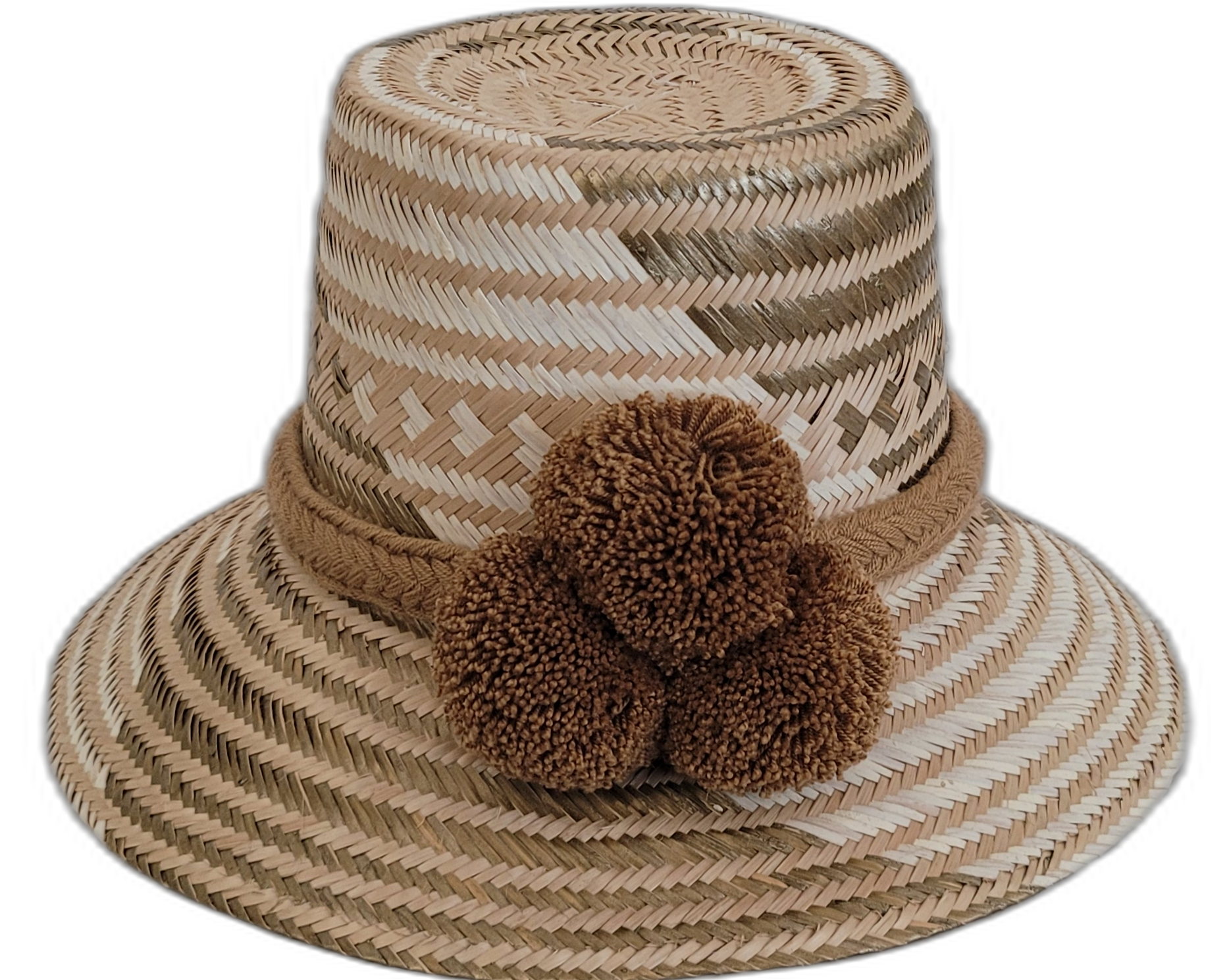 Handmade Wayuu straw hat in earthy beige tones with brown pompoms.

