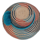 Artisan Wayuu hat, a handmade bohemian straw hat with colorful design and large decorative pompoms.

