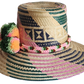 "Handmade, vibrant Wayuu hat crafted from Iraca palm fibers with culturally significant pompoms and adjustable fit."