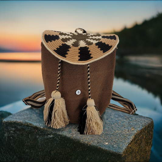 Handmade Wayuu backpack in brown with flap closure and neutral tassels.