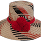 Handmade Wayuu straw hat with black, red, and natural weave, plus bold red pompoms.

