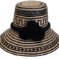 Handmade black Wayuu straw hat with matching black pompoms, artisan woven.

