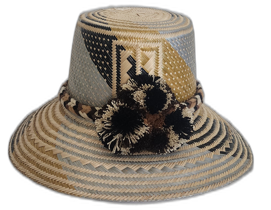 Handmade Wayuu straw hat with black and beige pompoms and geometric neutral design.Boho Wayuu hat with earth-toned colorblocking and cultural pattern
