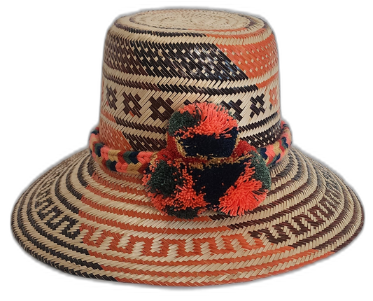 Handmade Wayuu straw hat with red, black, and green pompoms and tribal weave.