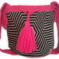 Boho-style Wayuu bag in tribal zigzag pattern, featuring bright pink crochet strap and tassels — artisan-made for modern bohemian fashion lovers.