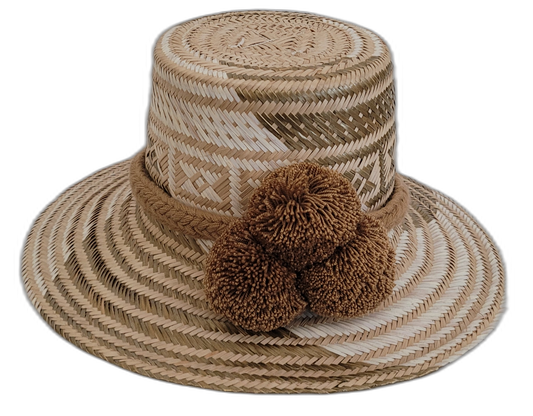 Handmade Wayuu straw hat with earthy brown tones and matching brown pompoms.

