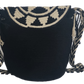 Artisan-crafted Wayuu bag featuring black and cream circular crochet design with fringe and chevron strap — bohemian and stylish.