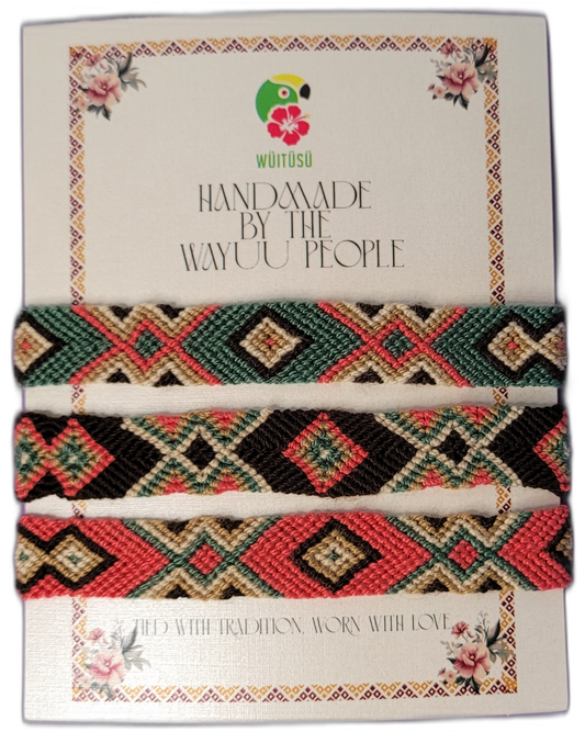 Handmade Wayuu friendship bracelets in coral, green, black, and cream with tribal geometric designs