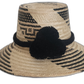Handmade Wayuu straw hat with black tribal pattern and black pompoms