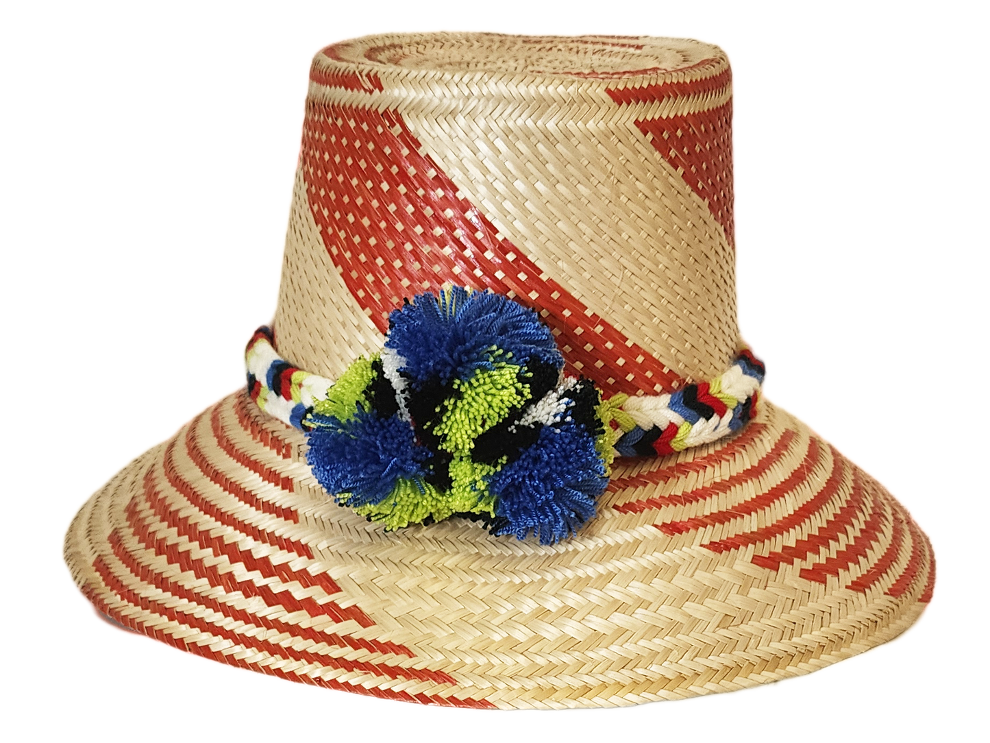 "Handmade Wayuu hat crafted from Iraca palm fibers, adorned with colorful pompoms, showcasing vibrant Wayuu craftsmanship."