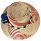 "Handmade Wayuu hat crafted from Iraca palm fibers, adorned with colorful pompoms, showcasing vibrant Wayuu craftsmanship."