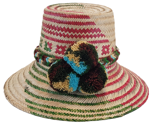 "Handmade Wayuu hat crafted from Iraca palm fibers with colorful pompoms, representing the Wayuu tribe's heritage."