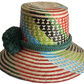 "Handmade Wayuu hat crafted from vibrant Iraca palm fibers, adorned with culturally significant pompoms for sun protection an