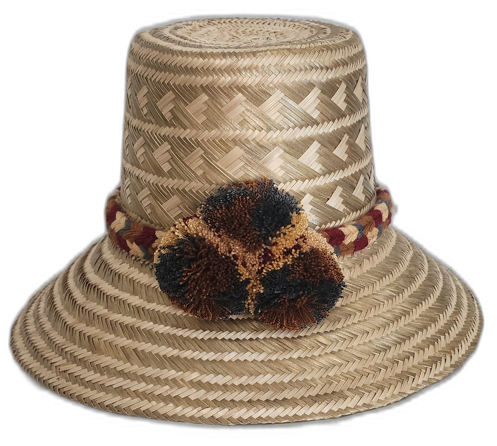 Handmade Wayuu straw hat with earth-tone weave and dark pompoms