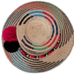 Handmade boho hat by Wuitusu with blue, red, and black colors and three pompom accents.

