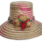Handmade Wayuu straw hat with pink and olive patterns and multicolor pompoms