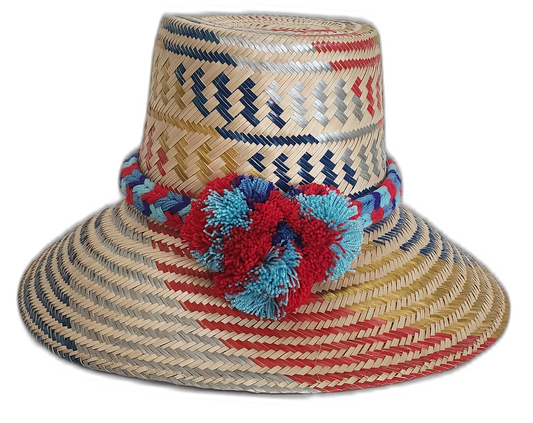 Handmade Wayuu straw hat with red, navy, and gold patterns and colorful pompoms