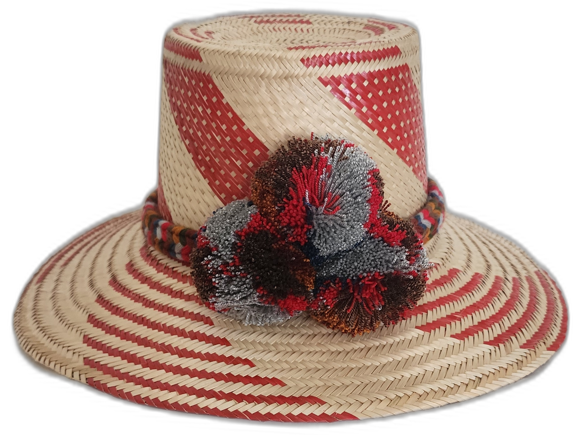 Handmade Wayuu straw hat with bold red diagonal weave and mixed pompoms