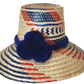 "Handmade Wayuu hat woven from Iraca palm fibers, decorated with colorful pompoms, symbolizing cultural heritage and prosperi