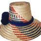 "Handmade Wayuu hat woven from Iraca palm fibers, decorated with colorful pompoms, symbolizing cultural heritage and prosperi