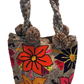 "Handmade Wayuu punch needle bag with colorful intricate designs, short handle, and lined interior, supporting Fair Trade and