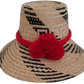 Handmade Wayuu straw hat with black and natural weave, accented by bright red pompoms.

