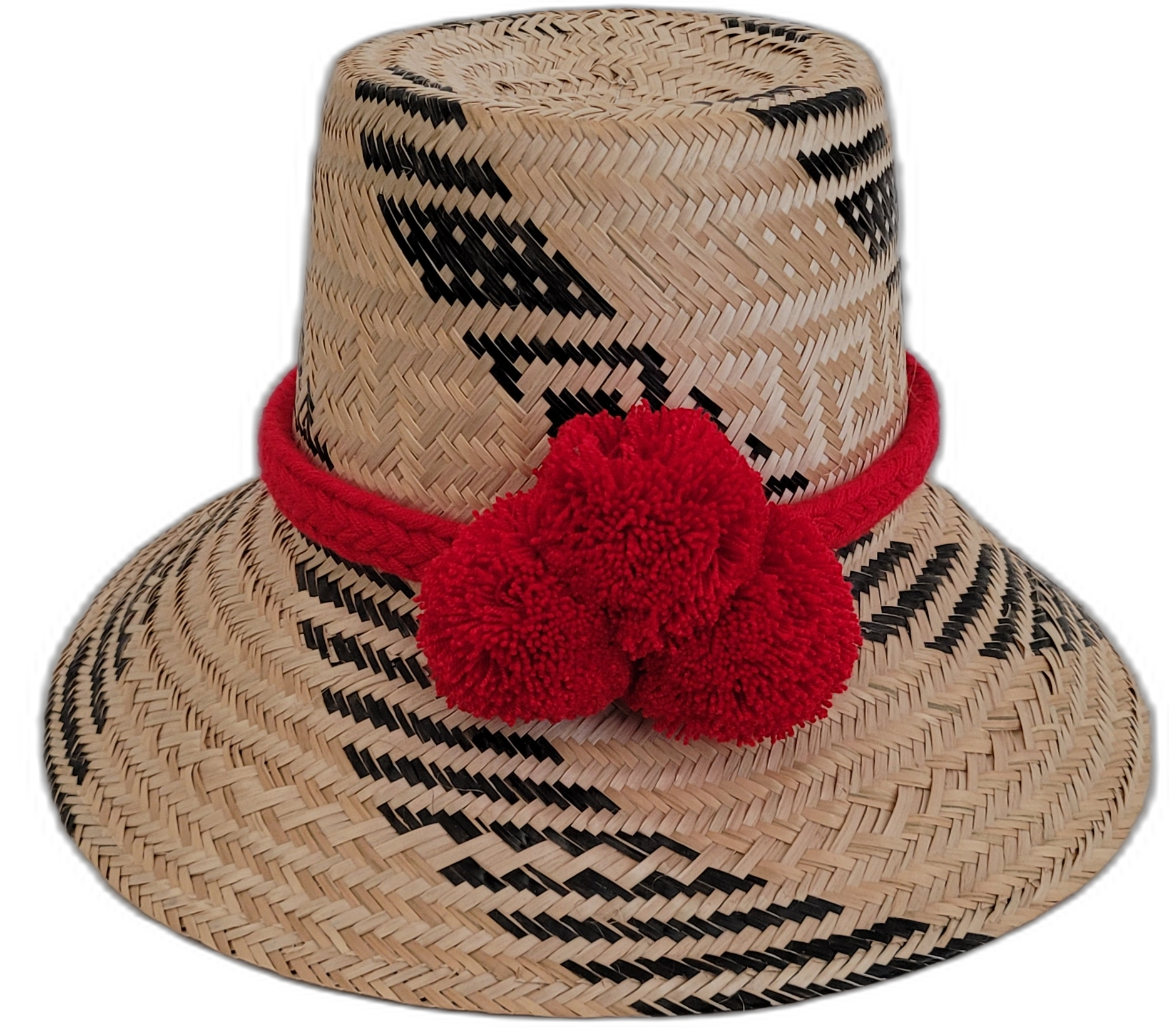 Handmade Wayuu straw hat with black and natural weave, accented by bright red pompoms.

