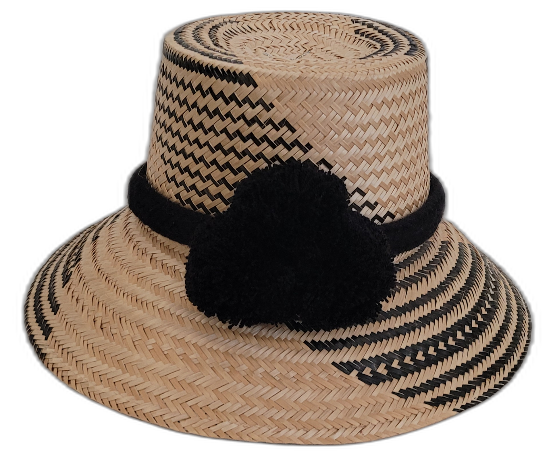 Handmade Wayuu straw hat with subtle black patterns and black pompoms.

