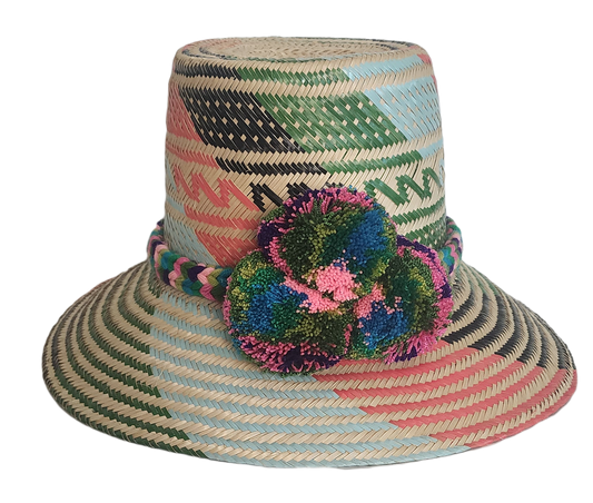 Handmade Wayuu straw hat with pink, green, and black woven patterns and multicolor pompoms.