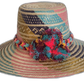 Handmade Wayuu straw hat with pink, teal, and burgundy pompoms