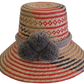 Handwoven Wayuu straw hat with red, navy, and natural patterns, featuring gray pom-poms and a braided band — boho summer accessory.