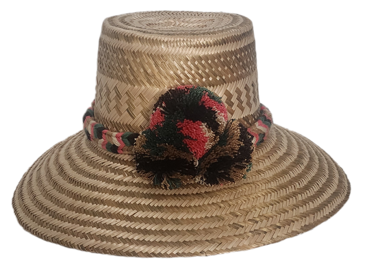 Handmade boho straw hat crafted by Wayuu artisans using natural Iraca palm, featuring an earth-tone braided band and multicolor pom-pom detail. Lightweight and perfect for summer style.
