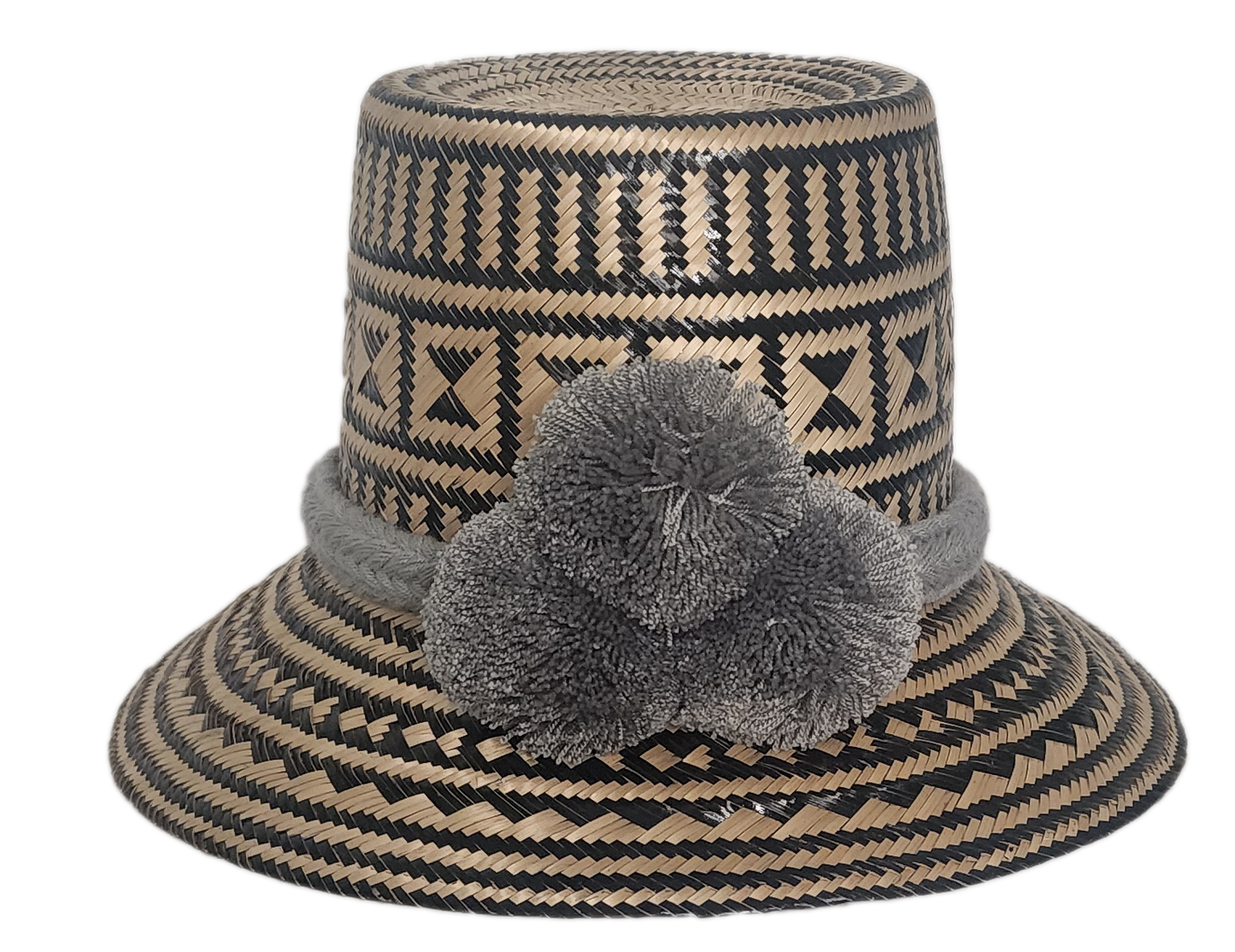 Handmade Wayuu straw hat with intricate black and natural geometric patterns, featuring a soft grey braided band and matching grey pom-poms.