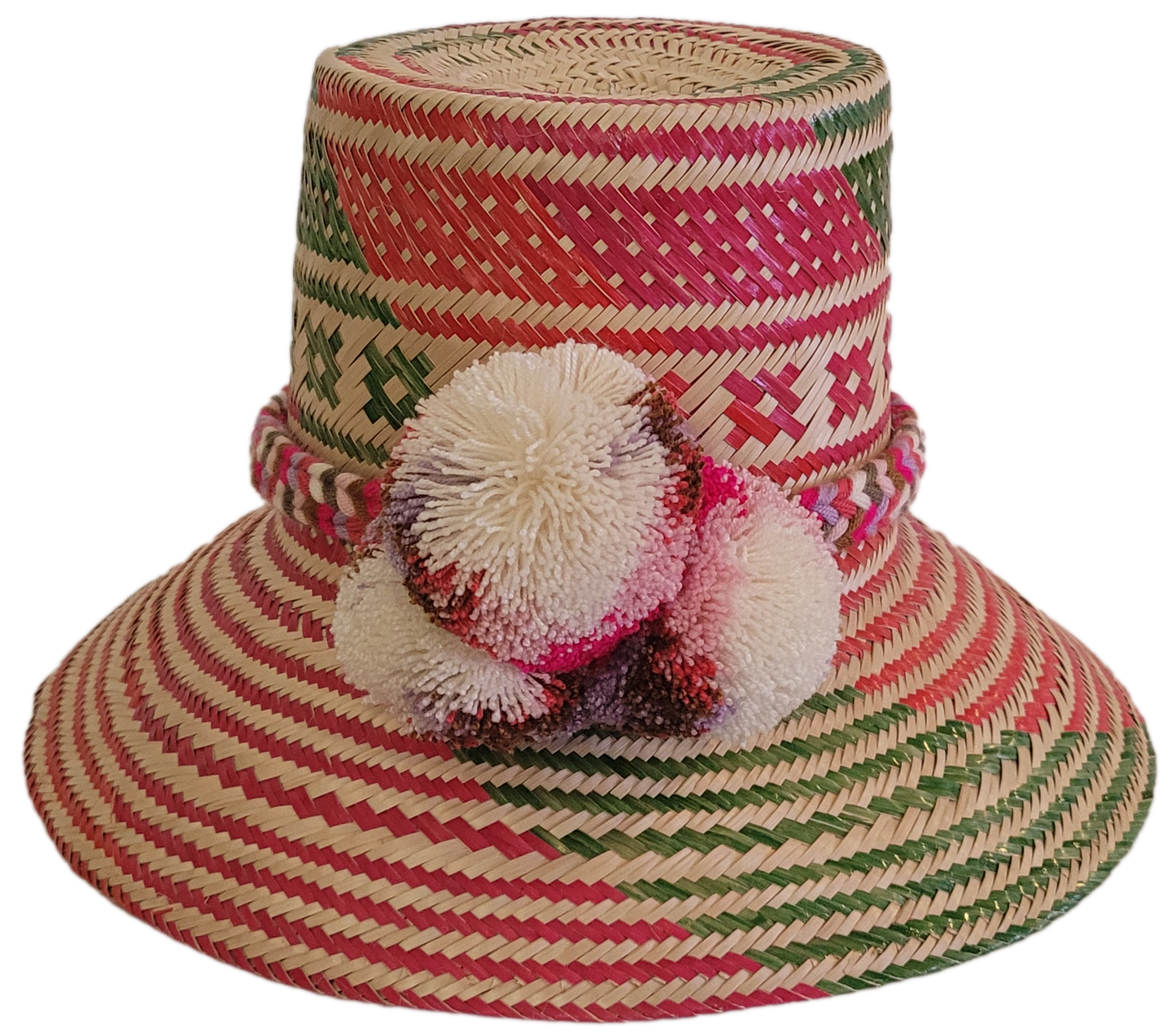 Colorful handmade Wayuu straw hat with pink, red, and green geometric patterns and multicolor pom-poms — artisan boho accessory for women.