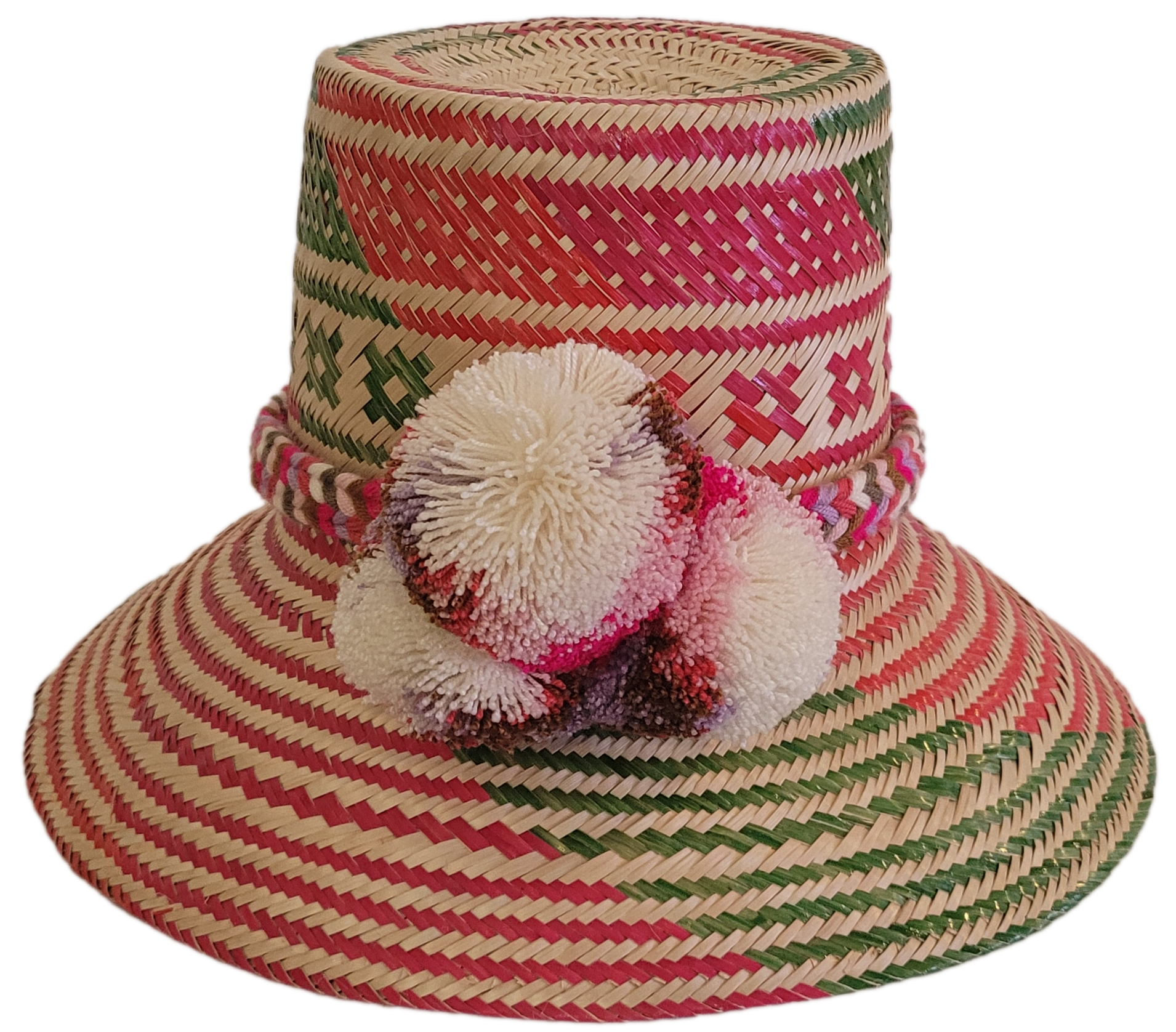 Colorful handmade Wayuu straw hat with pink, red, and green geometric patterns and multicolor pom-poms — artisan boho accessory for women.