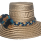 Boho straw hat handcrafted by Wayuu artisans, featuring a bold pom-pom trio in black, teal, and ochre tones, with a matching artisan band.