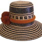 Boho-style Wayuu hat, handwoven from Iraca palm in black and natural tones, featuring a wide brim and rustic orange pom-poms for a unique finish.