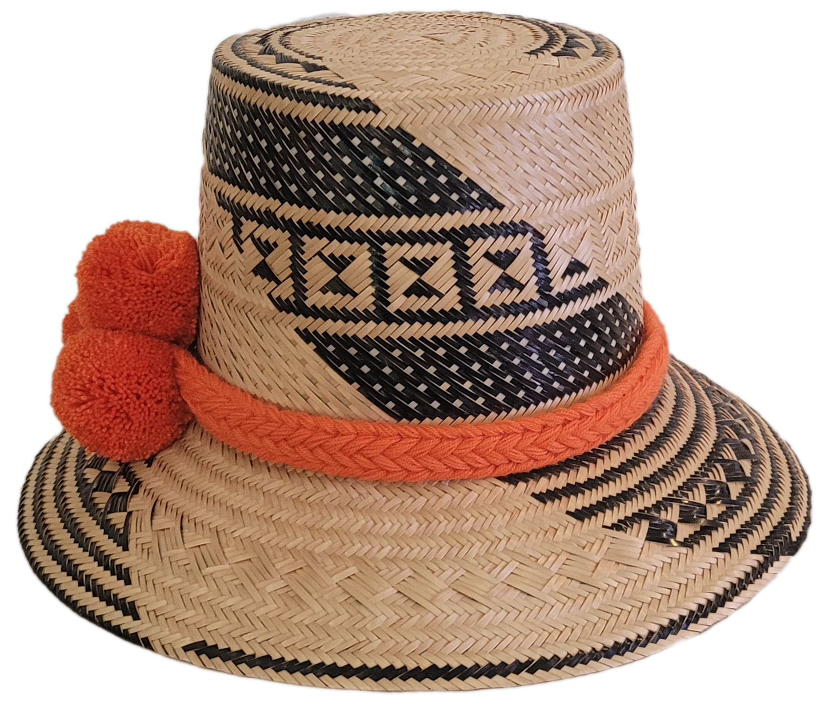 Bohemian-style artisan Wayuu hat with natural weave, black geometric accents, and vivid orange pom-poms — handcrafted for vibrant boho looks.