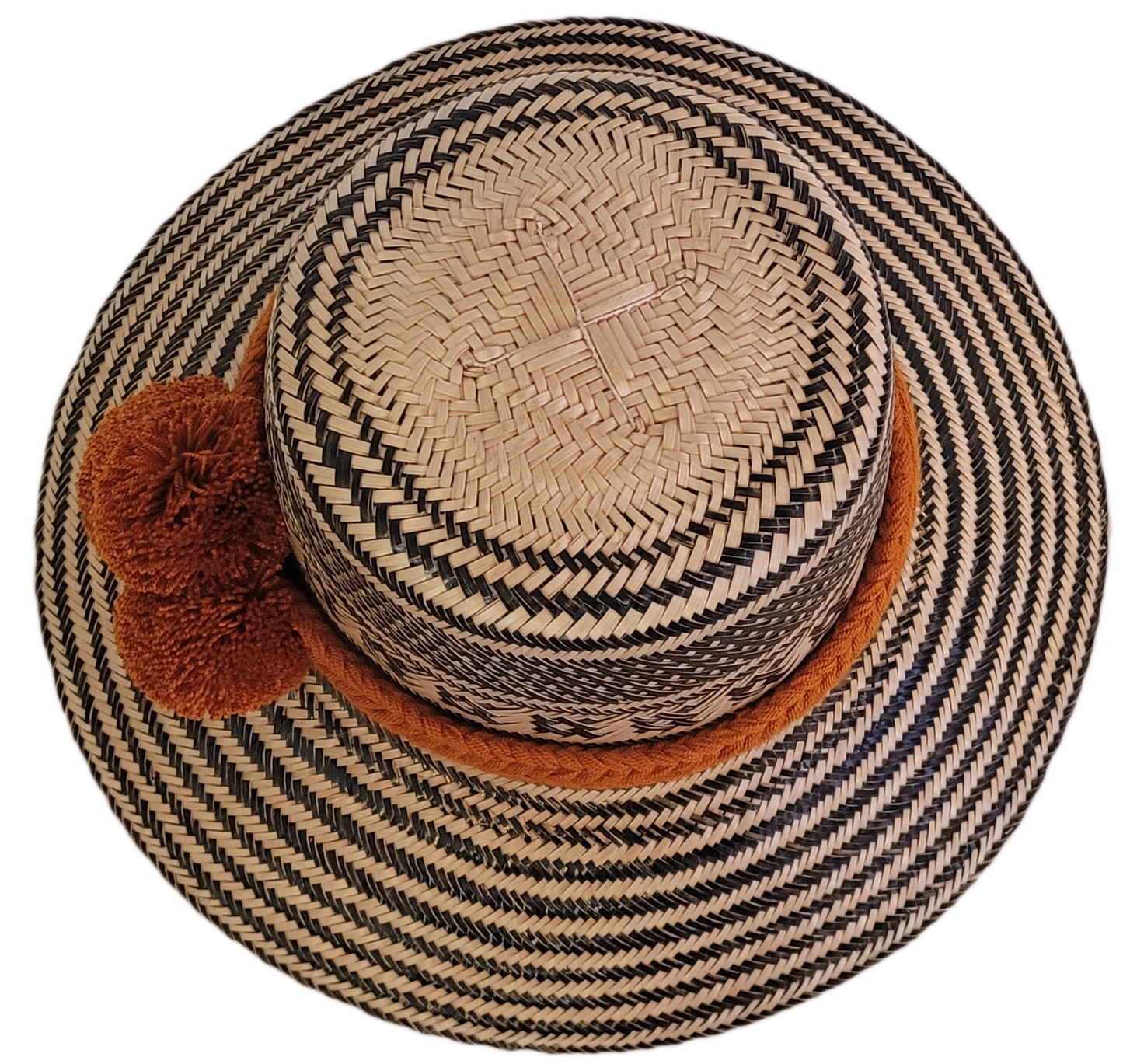 Artisan-crafted Wayuu straw hat with traditional patterns in black, finished with thick orange braided band and handmade pom-poms — perfect bohemian piece.