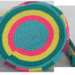 Image of a colorful, handmade crochet Wayuu bag featuring intricate bohemian patterns. This boho crossbody bag, created by indigenous Wayuu artisans from Colombia and Venezuela, showcases vibrant colors and geometric motifs inspired by the Guajira Peninsula. The bag varies in size and includes adjustable straps, making it both stylish and functional for everyday use or beach outings.