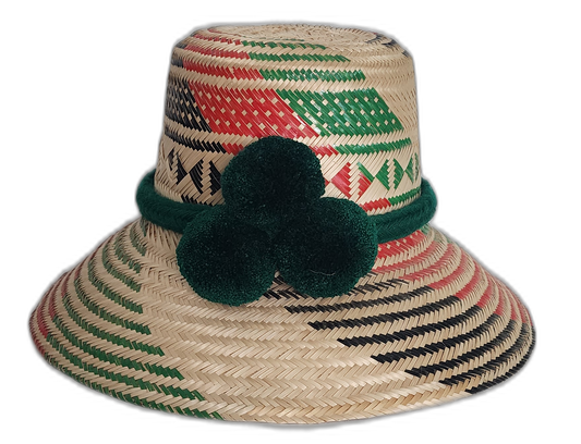 Handmade Wayuu straw hat with red, green, and black weave and green pompoms.Lilliana handmade Wayuu hat with green, red, and black geometric weave and pompoms

