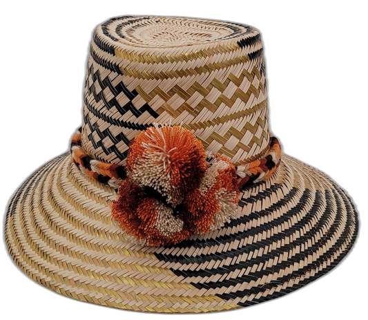 Margo handmade Wayuu straw hat with black and green weave and rust-orange pompoms

