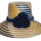 Handmade Wayuu straw hat in yellow and navy with bold navy pompoms.Maria handmade Wayuu hat with yellow and navy diagonal weave and blue pompoms in Bohemian colors